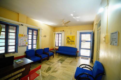 a waiting room with blue chairs and a table at Kamal Homes in Kīhīm