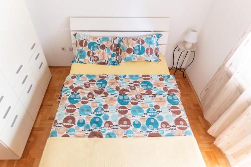 1 dormitorio con cama con colcha en The Urban Nest en Skopje