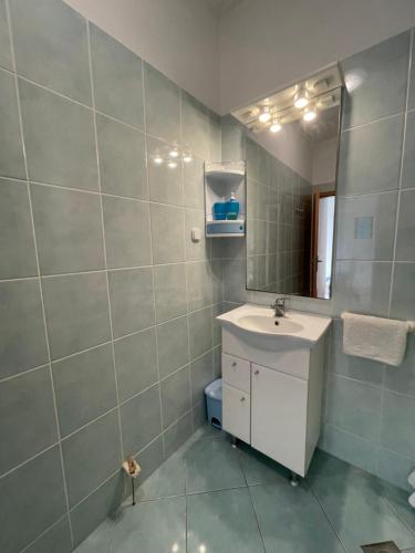 uma casa de banho com um lavatório e um espelho em Seaview apartments em Poljica