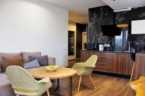 un soggiorno con tavolo, sedie e divano di Amsterdam Lviv Apartments a Lviv
