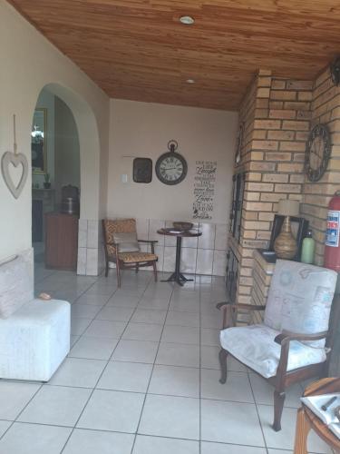 sala de estar con sillas y reloj en la pared en Breaking Dawn, en Noupoort