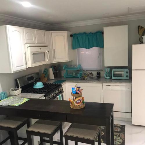 a kitchen with white cabinets and a table with chairs at The Haven Hideaway & Platinum in Freeport