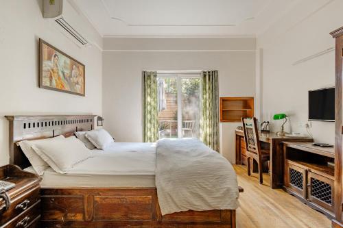 Dormitorio con cama, escritorio y TV en Cp Villa - Rooms with Patio en Nueva Delhi
