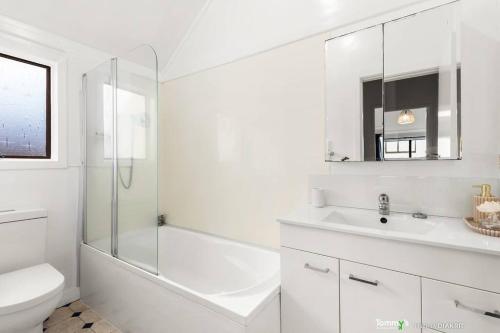 a white bathroom with a sink and a shower at Beachside Retreat in Wellington