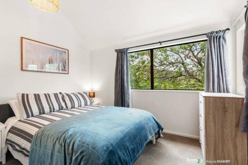 1 dormitorio con cama y ventana grande en Beachside Retreat, en Wellington
