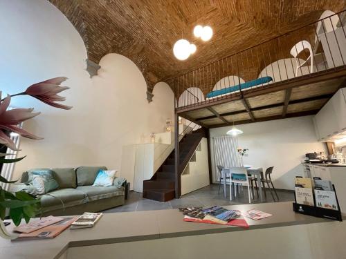 a living room with a couch and a staircase at Atelier Cimabue in Arezzo
