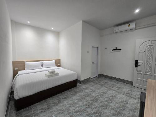 - une chambre avec un lit blanc et une porte dans l'établissement Triple D Hotel, à Betong