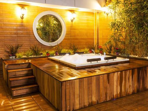a large bath tub in a room with a mirror at Nidya Hotel Esenyurt in Istanbul