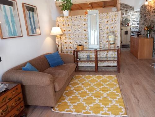a living room with a couch and a rug at Casa das Mouriscas in Casalão