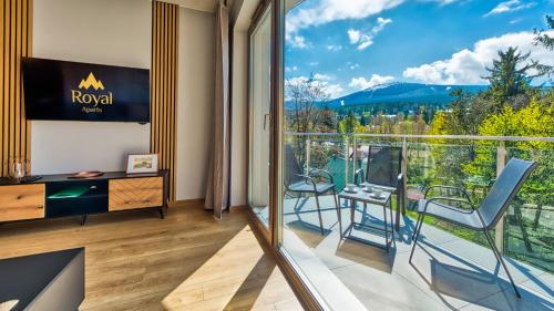 a room with a balcony with a view of the mountains at Apartamenty z basenem i saunami STONE HILL RESORT II VIP Centrum by Royal Aparts in Szklarska Poręba