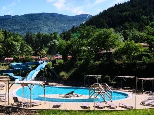 une piscine avec toboggan et un parc aquatique dans l'établissement Camping Le Couriou - Maeva, à Recoubeau-Jansac