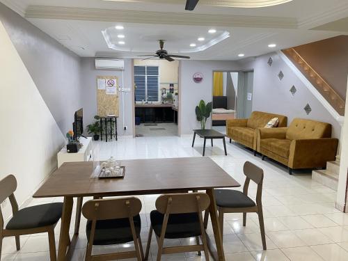 a dining room and living room with a table and chairs at 8min Port Dickson beach 17pax Pet Friendly in Port Dickson