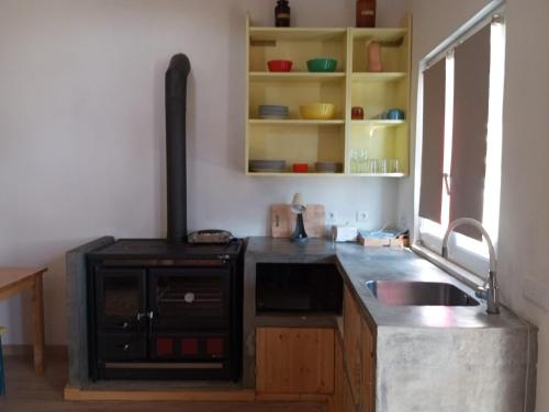 a kitchen with a sink and a stove at Casa das Mouriscas in Casalão