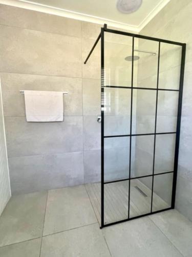 una ducha con puerta de cristal en un baño en Groenvlei Guest Farm, en Kuilsrivier