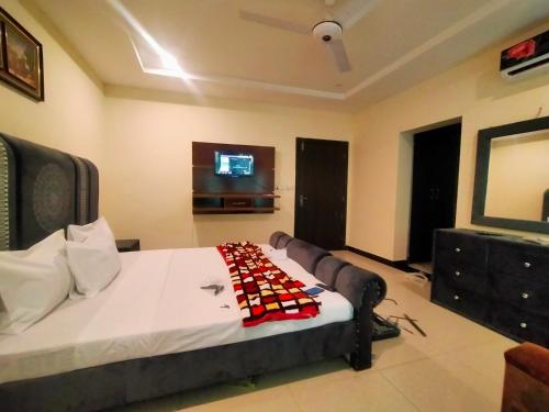 a bedroom with a bed and a tv on the wall at Peridot Vacation Inn, Bahria in Mingora