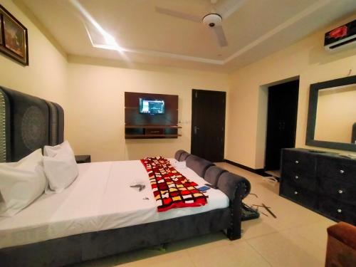 a bedroom with a bed and a tv on the wall at Peridot Vacation Inn, Bahria in Islamabad