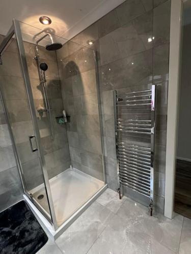 a shower with a glass door in a bathroom at 230 Councillor Lane in Cheadle