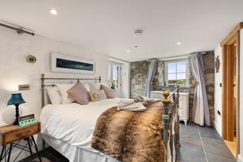 a bedroom with a large bed in a room at Swn y Môr - 1 Bedroom Cottage - Whitesands in St. Davids