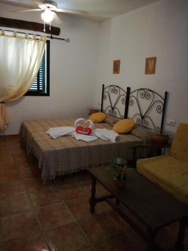 a bedroom with two beds and a table and a chair at Casa Rural El Cubillo in Vejer de la Frontera