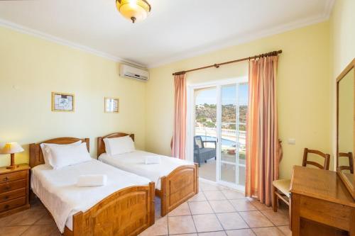a hotel room with two beds and a balcony at Villa Vista Marina in Albufeira