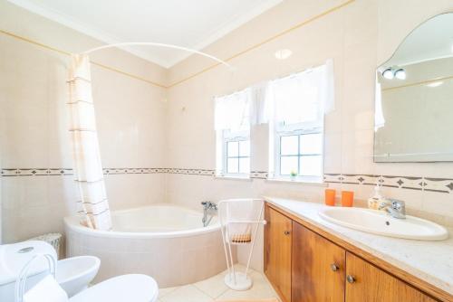 a bathroom with a tub and a sink at Filomena Golf Paradise in Guia