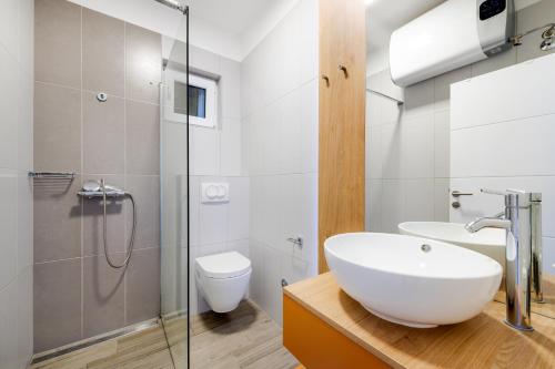 bagno bianco con lavandino e servizi igienici di Ojra NEW apartment with seaview a Šibenik