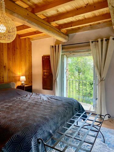 une chambre avec un lit et une grande fenêtre dans l'établissement Le 1830, à Églisolles