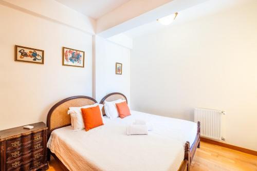 ein Schlafzimmer mit einem Bett mit orangefarbenen Kissen in der Unterkunft Apartamento Vista Marina in Albufeira