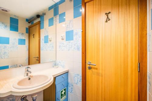 ein Badezimmer mit einem Waschbecken und einer Holztür in der Unterkunft Apartamento Vista Marina in Albufeira