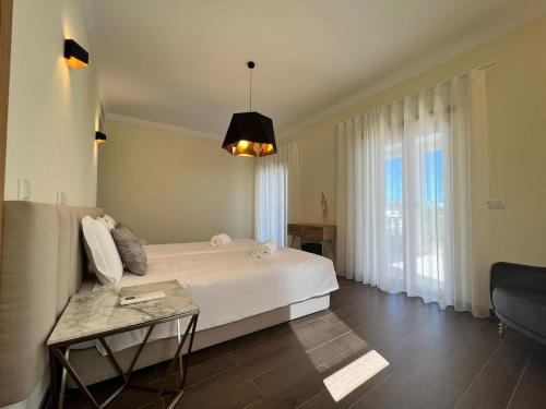 Un dormitorio con una cama grande y una mesa. en Light House Luxury Villa, en Albufeira