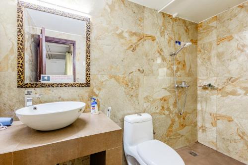 a bathroom with a sink and a toilet and a mirror at Cp Villa - Rooms with Patio in New Delhi
