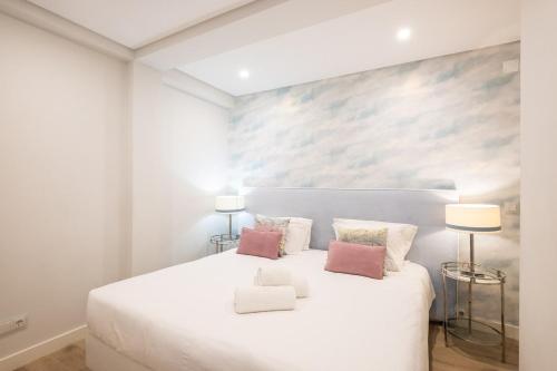 - une chambre blanche avec un grand lit blanc et deux lampes dans l'établissement Marina Design T1, à Albufeira