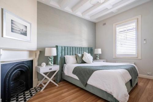 a bedroom with a bed and a fireplace at Green Stays in Sydney