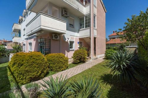 a large pink and white house with a garden at Apartment in Funtana/Istrien 31340 in Funtana