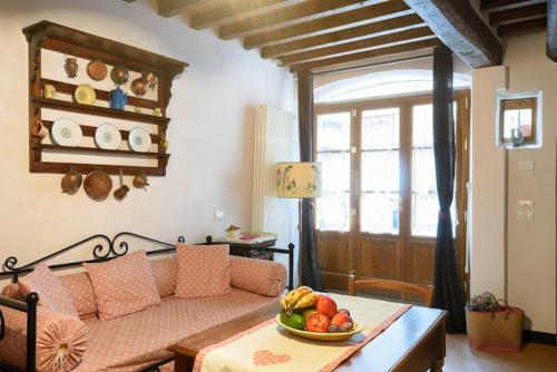 ein Wohnzimmer mit einem Sofa und einer Obstschale auf einem Tisch in der Unterkunft Deliziosa casetta in centro! in Cortona