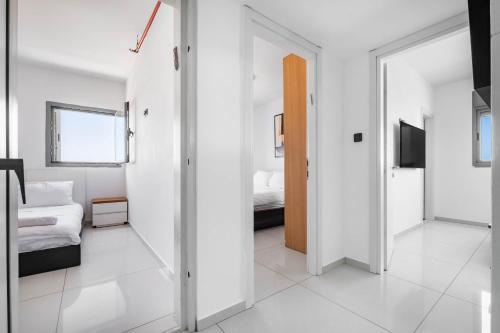 a white room with a bed and a sliding door at Ocean View Oasis with Balcony for families in Ashdod