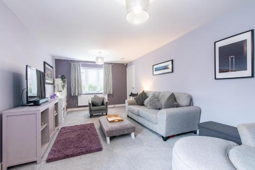 een woonkamer met een bank en een tv bij 4 Bedroom Detached House Ideal for Families and Corporate Stays in Radcliffe on Trent in Burton Joyce