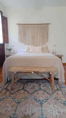a bedroom with a large bed and a wooden bench at Casa Rural Casa Selmo in Carreno