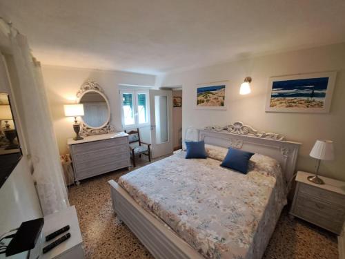 ein Schlafzimmer mit einem Bett mit blauen Kissen und einem Spiegel in der Unterkunft Casetta vista mare in Antona