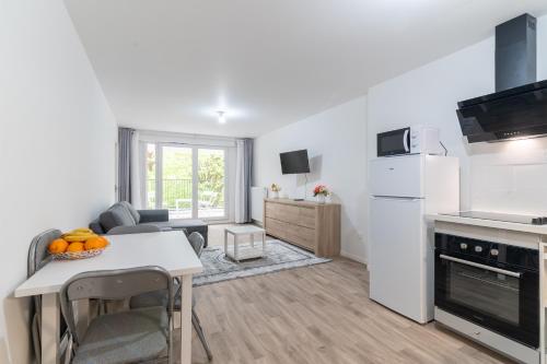un salon avec une cuisine et une table avec des oranges dessus dans l'établissement Moulin à Vent Sud - Appt à 20 min de Paris, à Bondy