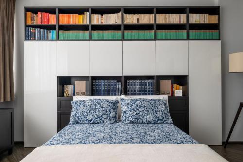 a bedroom with a bed with a wall of books at Forlì Park View in Forlì