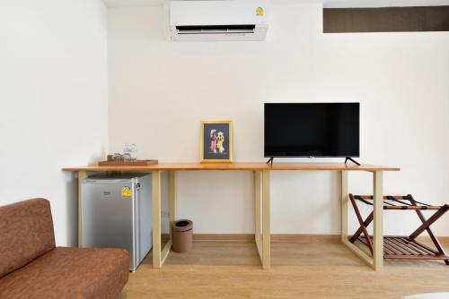 a desk with a television on top of it at Ratchathewi Hyde Away in Pratunam