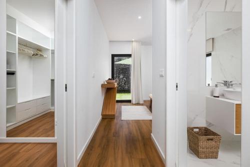 un bagno bianco con lavandino e specchio di Quinta do Refúgio a Rabo de Peixe