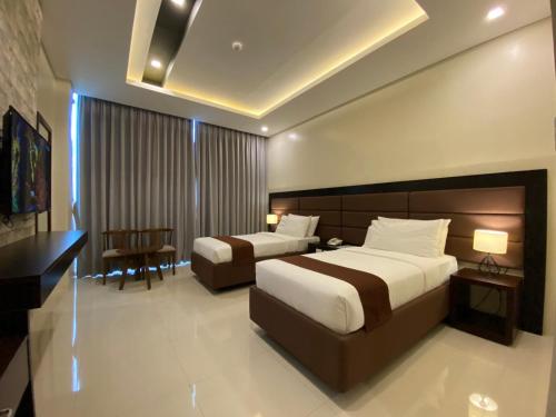 Lapu Lapu CityにあるWinrich Hotelのベッド2台とデスクが備わるホテルルームです。