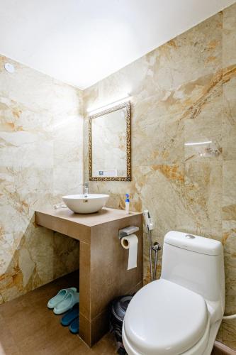 a bathroom with a white toilet and a sink at Cp Villa - Rooms with Patio in New Delhi