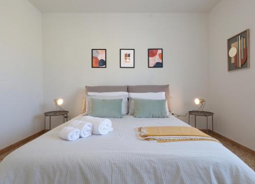 1 dormitorio con 1 cama blanca grande y toallas. en Tuscany Best Point [Stazione], en Montale
