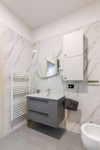 a white bathroom with a sink and a mirror at Residenza Il Castello, Cervia. in Cervia