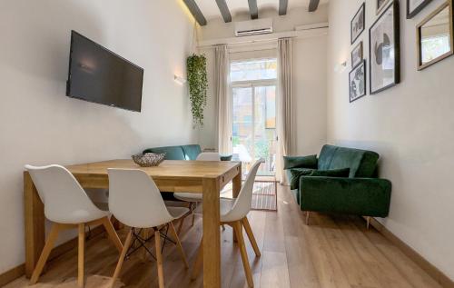 a dining room with a table and chairs and a television at Aqua Apartment by Olala Homes in Barcelona