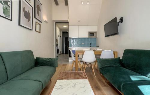 バルセロナにあるAqua Apartment by Olala Homesのリビングルーム(緑のソファ付)、キッチン