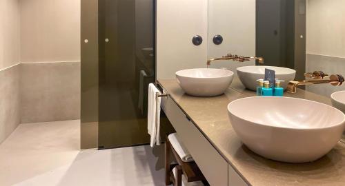 a bathroom with two white sinks on a counter at PortoBay Teatro in Porto